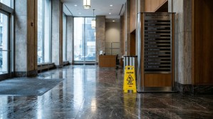 Caution wet floor sign on marble lobby floor near building directory