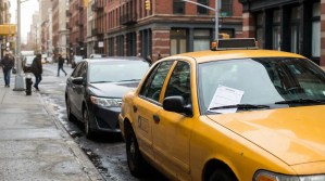 taxi cab with insurance document on dashboard parked on urban city street