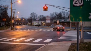 sedan stopped at red traffic light near Route 20 sign and crosswalk